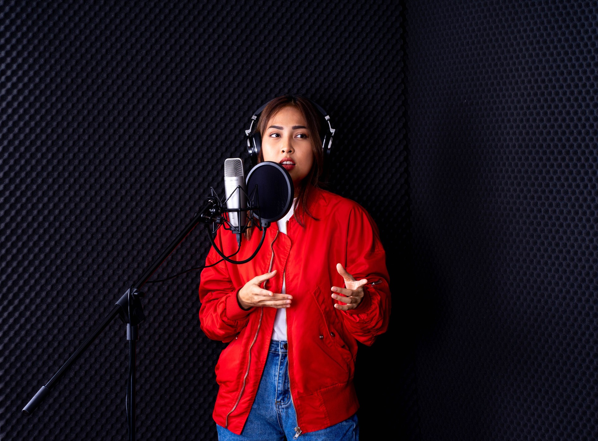 junge attraktive asiatische Musikerin Sängerin im Recoding Studio mit Mikrofon. Performance-Arts-Konzept.
